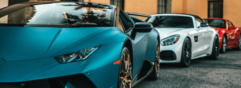 Plusieurs voitures de sport comme Porche et Lamborghini sont garés. importation courtier auto.